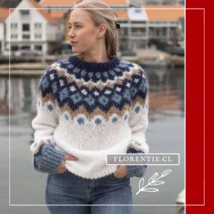 Modelo de frente luciendo sweater nórdico crema con canesú geométrico azul marino y camel, combinado con jeans, fondo portuario escandinavo.