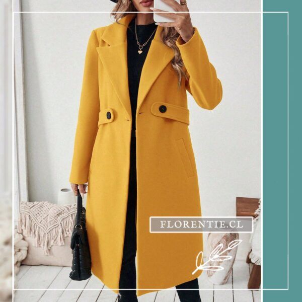 Modelo con abrigo largo amarillo de doble botonadura negra contrastante, bolso negro y look urbano completo