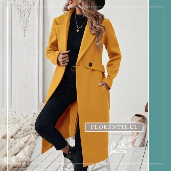 Modelo con sombrero negro y abrigos color amarillo mujer mostrando bolsillos laterales y caída recta, ambiente urbano