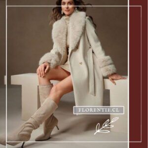 Modelo sentada luciendo abrigo largo blanco crema con cuello y puños de pelo sintético, combinado con botas altas beige.