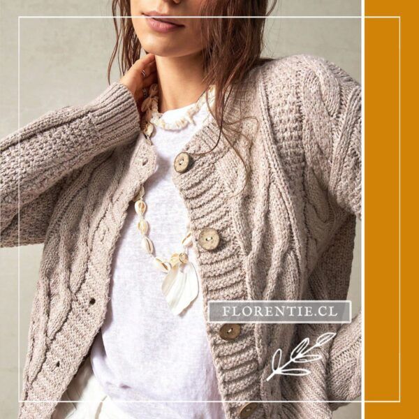 Modelo con cárdigan abotonado beige tostado de punto grueso combinado con camiseta blanca y collar de conchas, vista frontal media.