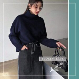 Vista completa de modelo luciendo chaleco azul marino holgado con falda midi de mezclilla gris y bolso negro.