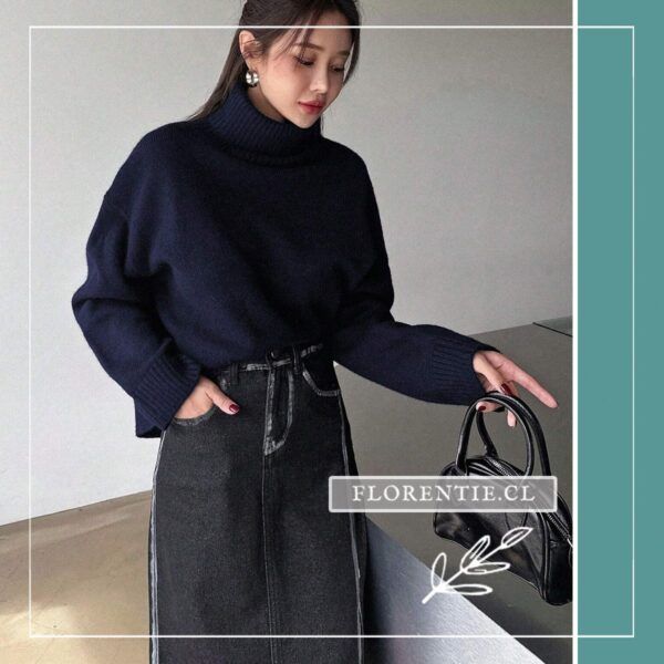 Vista completa de modelo luciendo chaleco azul marino holgado con falda midi de mezclilla gris y bolso negro.