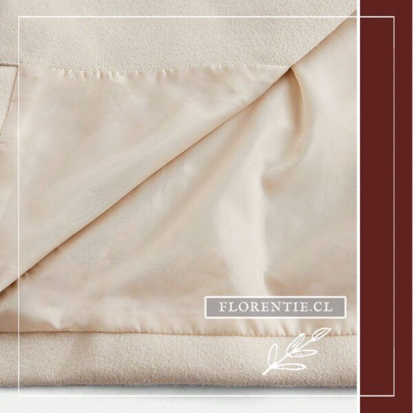 Vista interior del abrigo blanco crema para mujer mostrando el suave forro satinado beige.