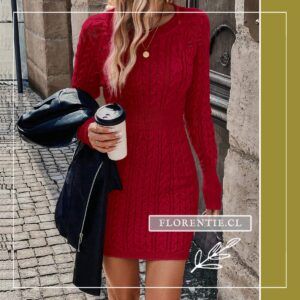 Modelo caminando con vestido rojo tejido patron trenzas sosteniendo cafe y chaqueta de cuero negra en brazo, calle empedrada europea.