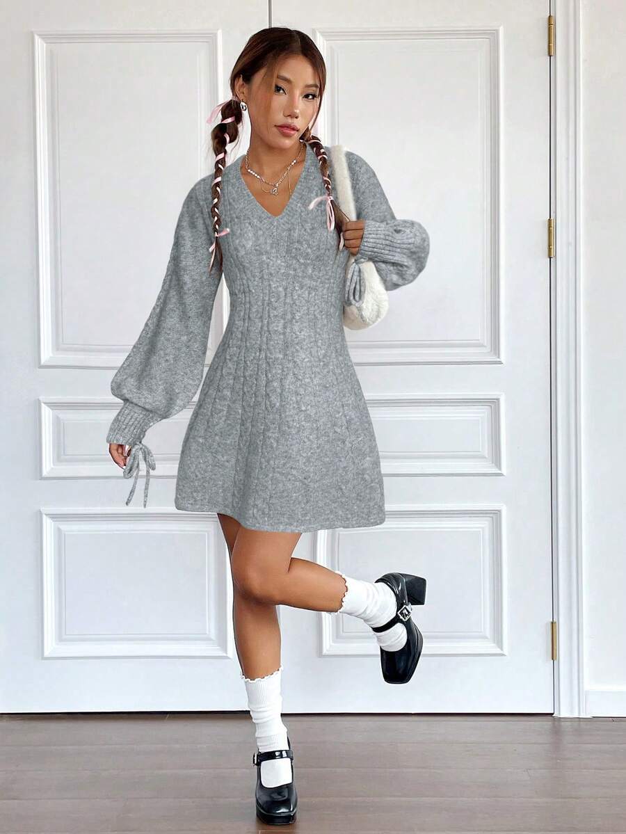 Look completo con vestido gris de punto y manga globo, combinado con calcetines blancos altos, zapatos mary jane negros y bolso peluche blanco