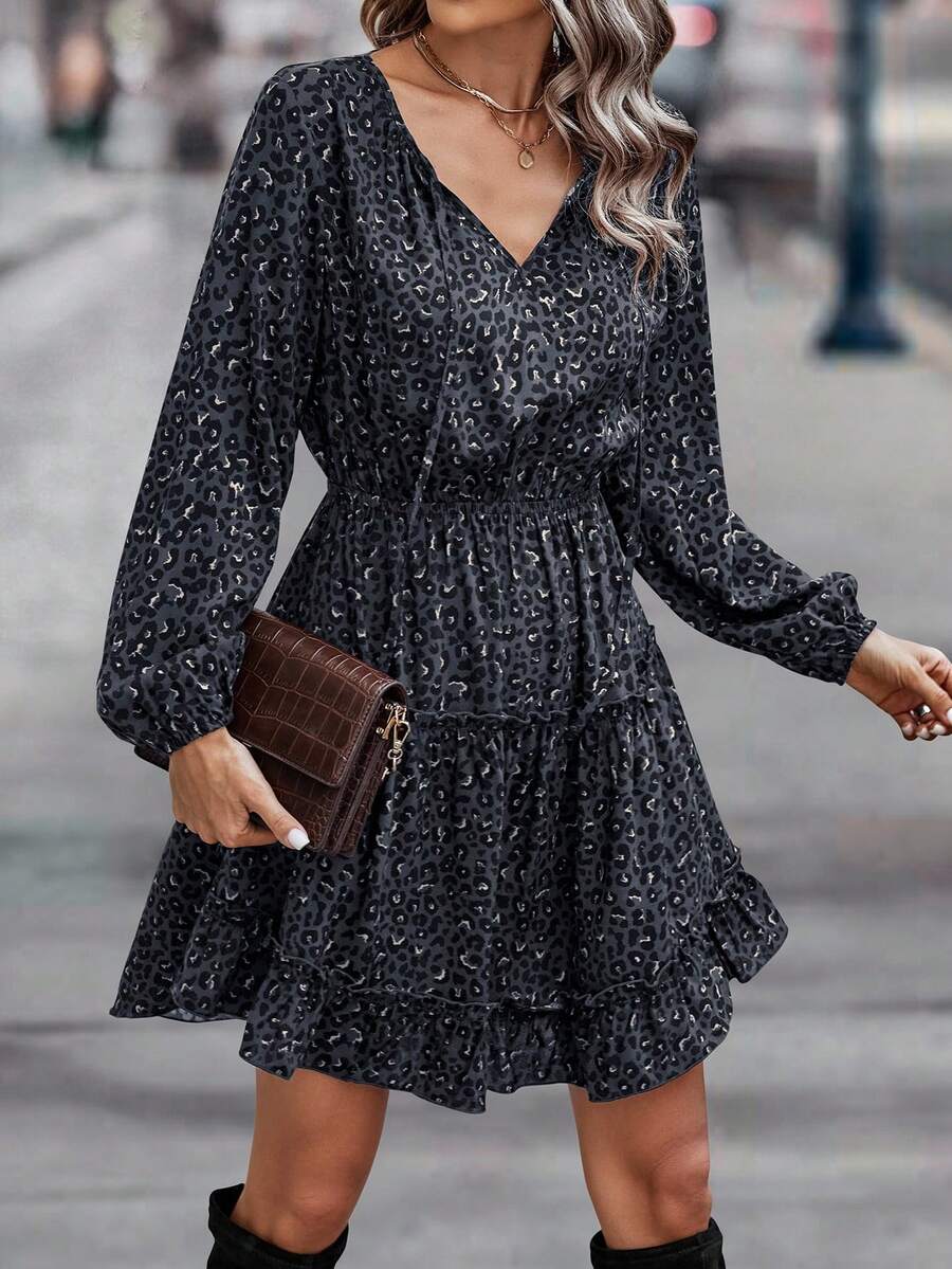 Mujer luciendo vestido corto animal print con escote en V pronunciado, cartera café textura cocodrilo y collar dorado en calle