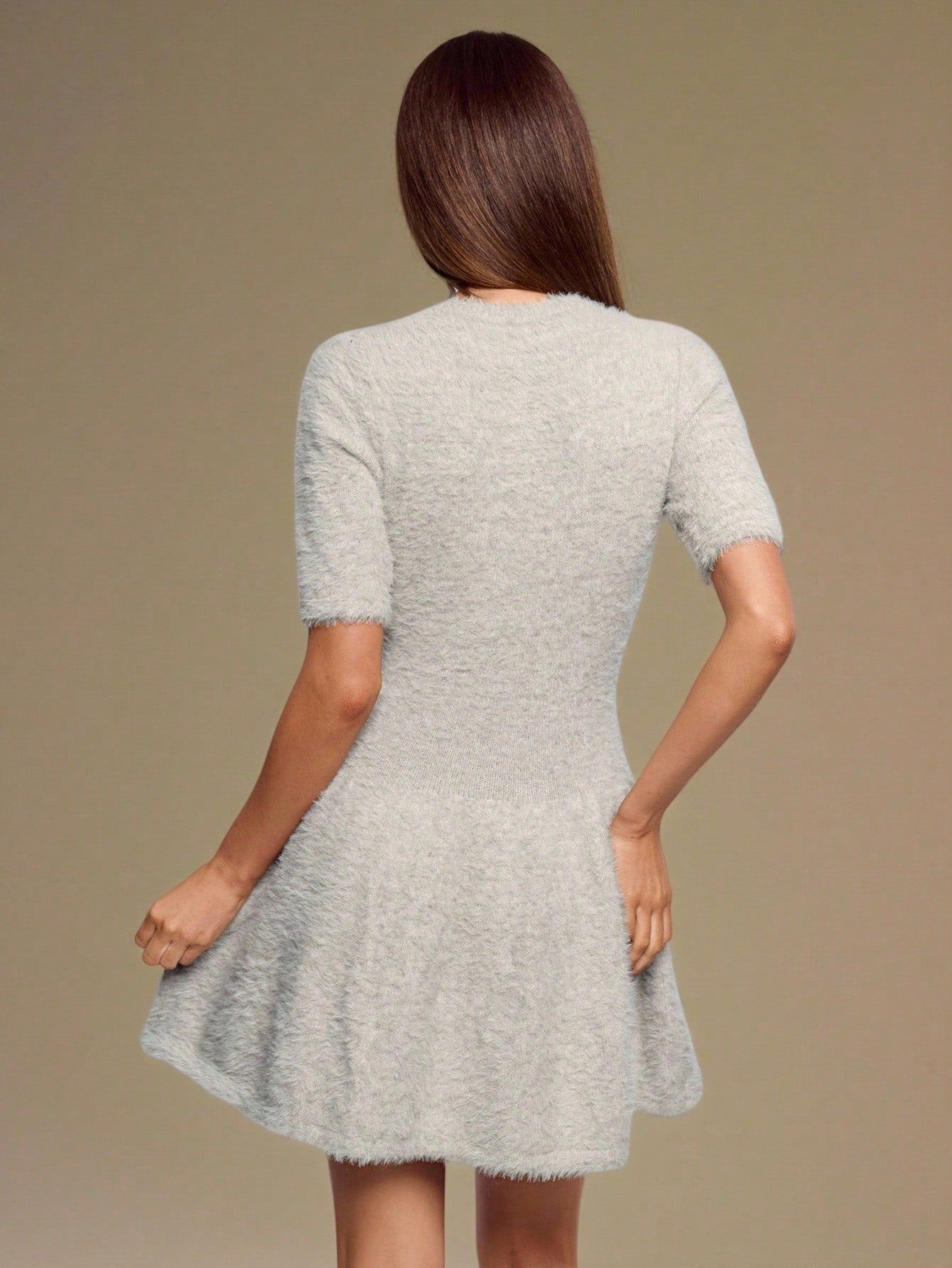 Vista trasera de vestido gris fuzzy mostrando espalda cerrada, manga corta y caída amplia de la falda acampanada