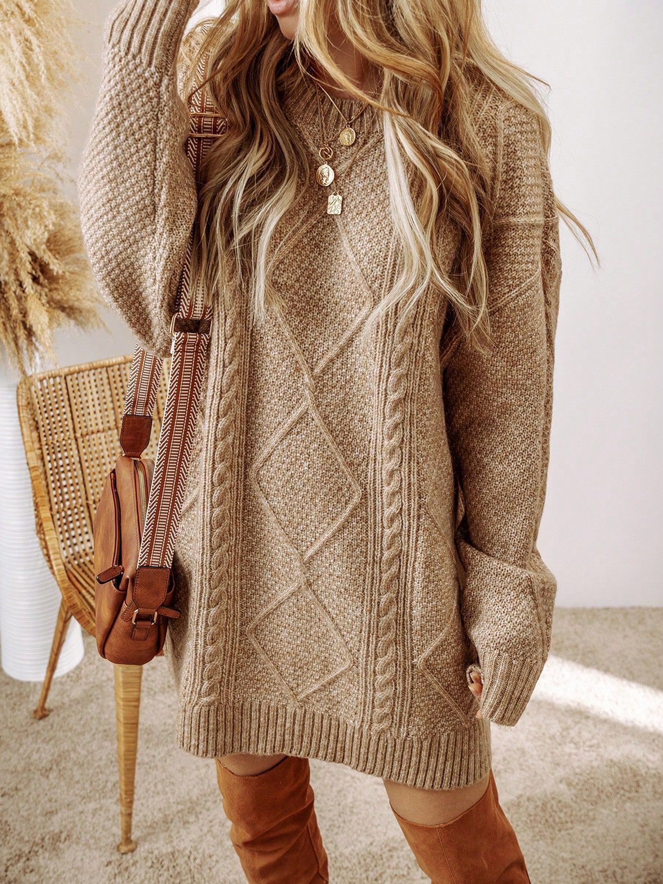 Detalle del torso mostrando vestido punto beige con textura de rombos, collares dorados, modelo con botas altas camel sobre fondo neutro