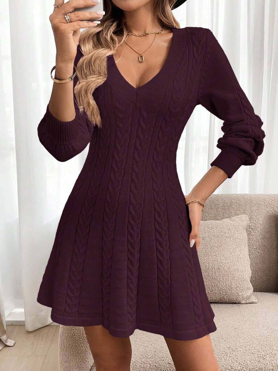 Modelo con vestido de punto burdeo con trenzas verticales, cuello V profundo y manga larga, tomando selfie en sala con sofá beige