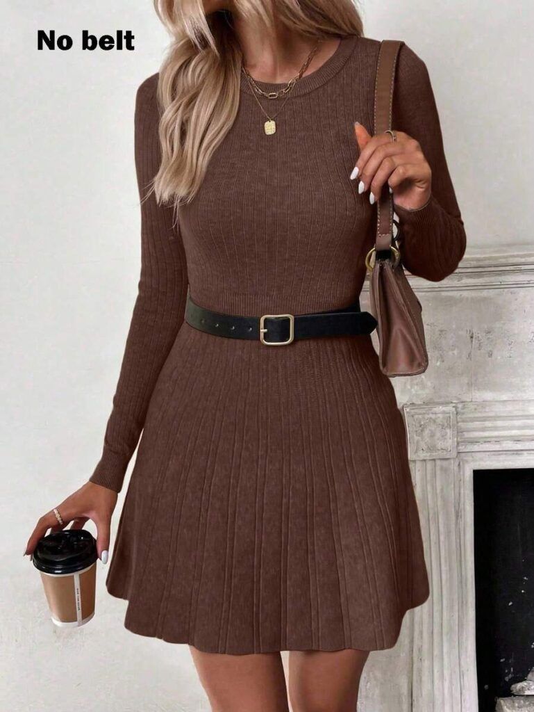 Modelo con vestido de punto café chocolate manga larga, falda acampanada acanalada, cuello redondo, sosteniendo vaso de café junto a chimenea blanca