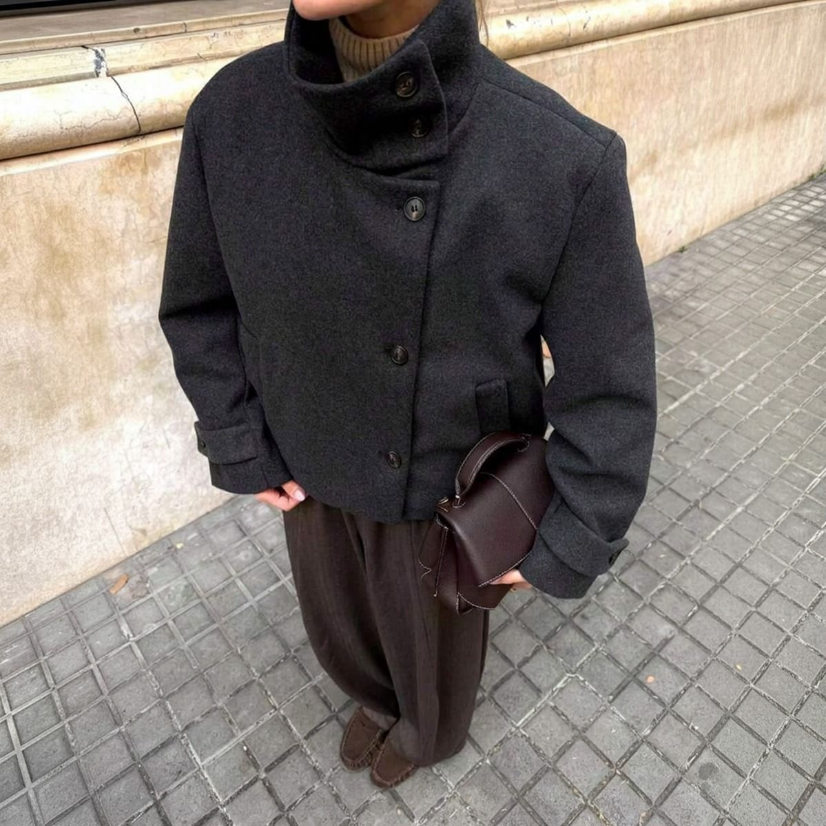 Abrigo de paño gris oscuro cuello alto con botones, vista frontal completa combinado con pantalón marrón