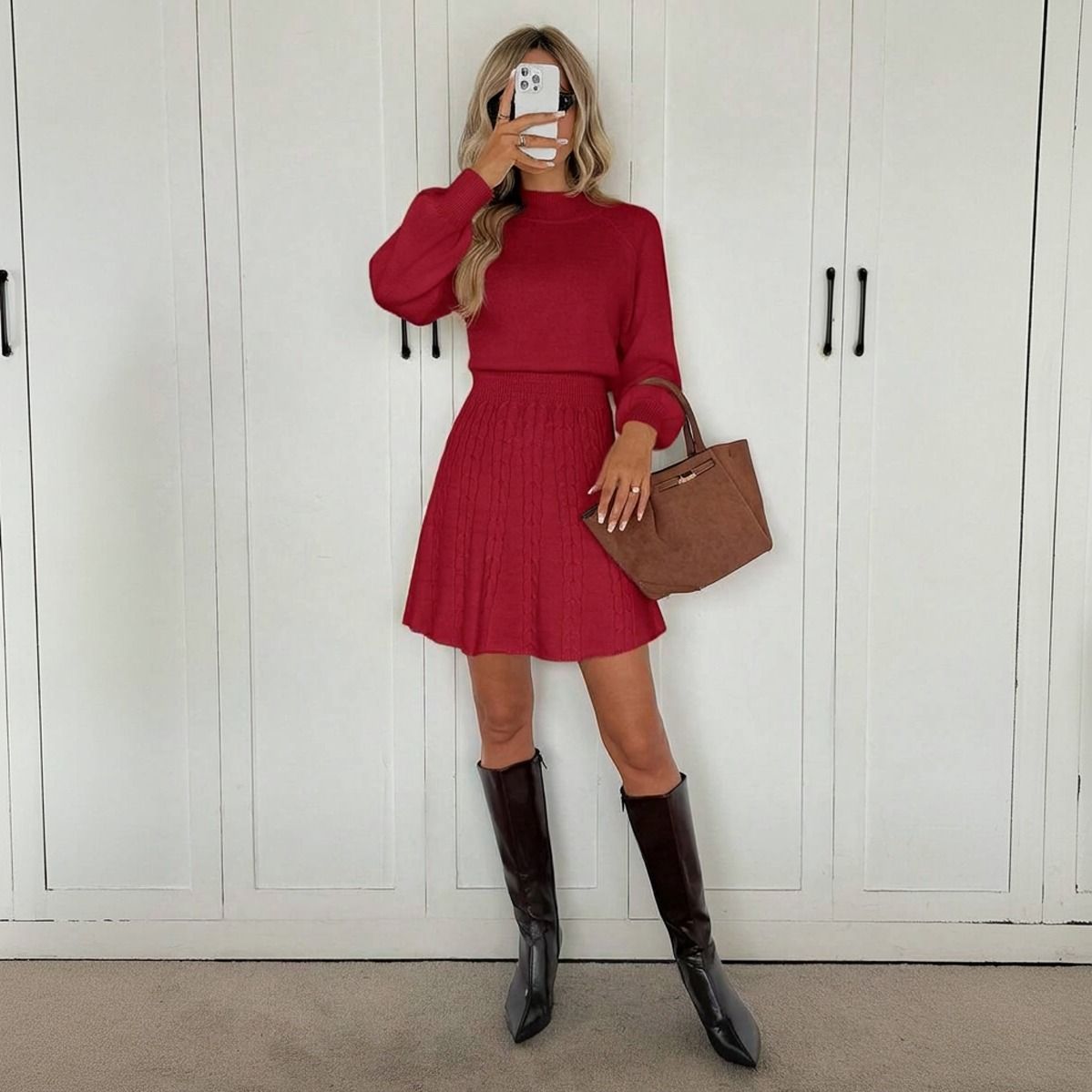Conjunto tejido rojo de cuerpo entero frente a armario, sweater con cuello mock y falda acampanada con botas altas
