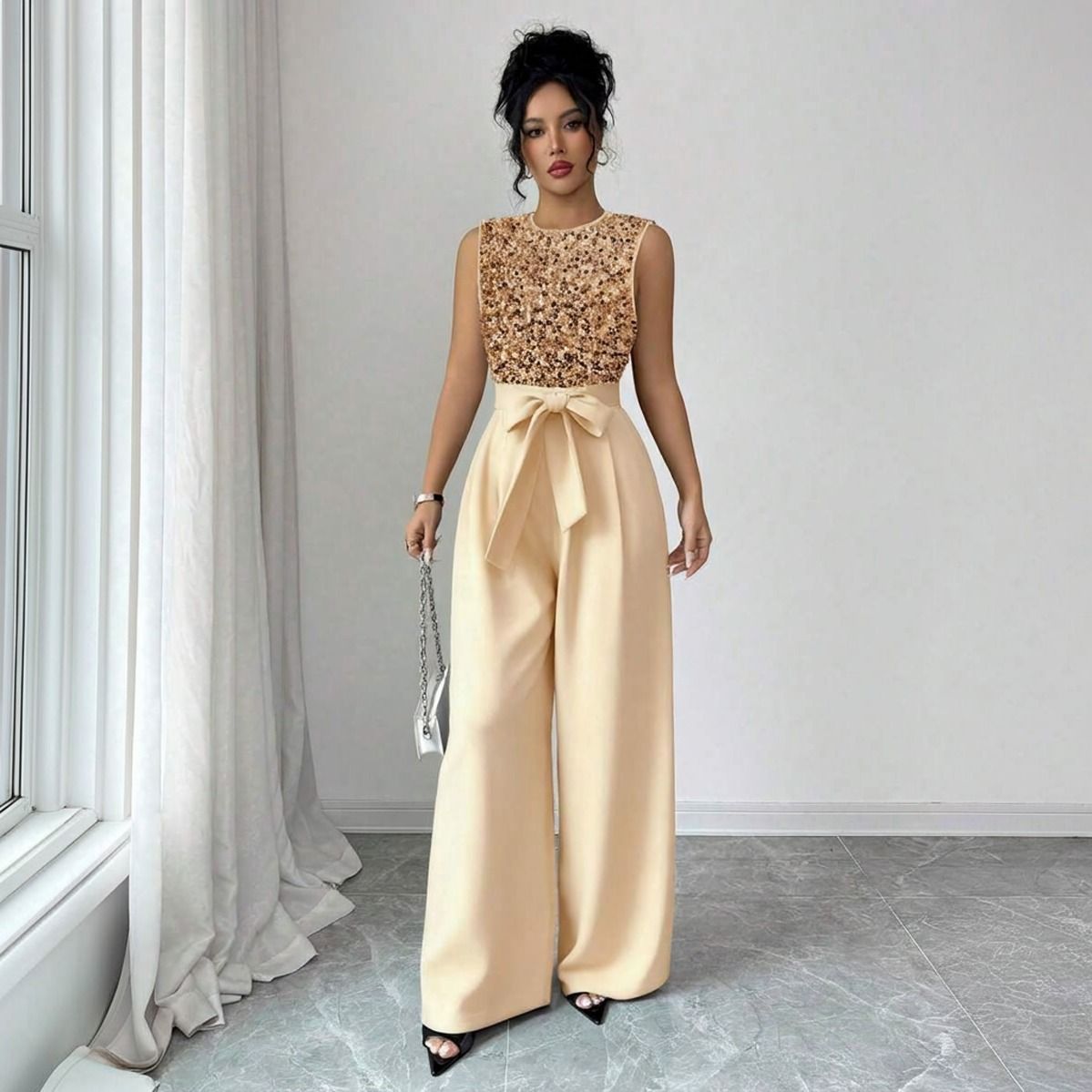 Enterito de fiesta dorado con cuerpo de lentejuelas cobrizas y pantalon palazzo champagne visto de frente completo