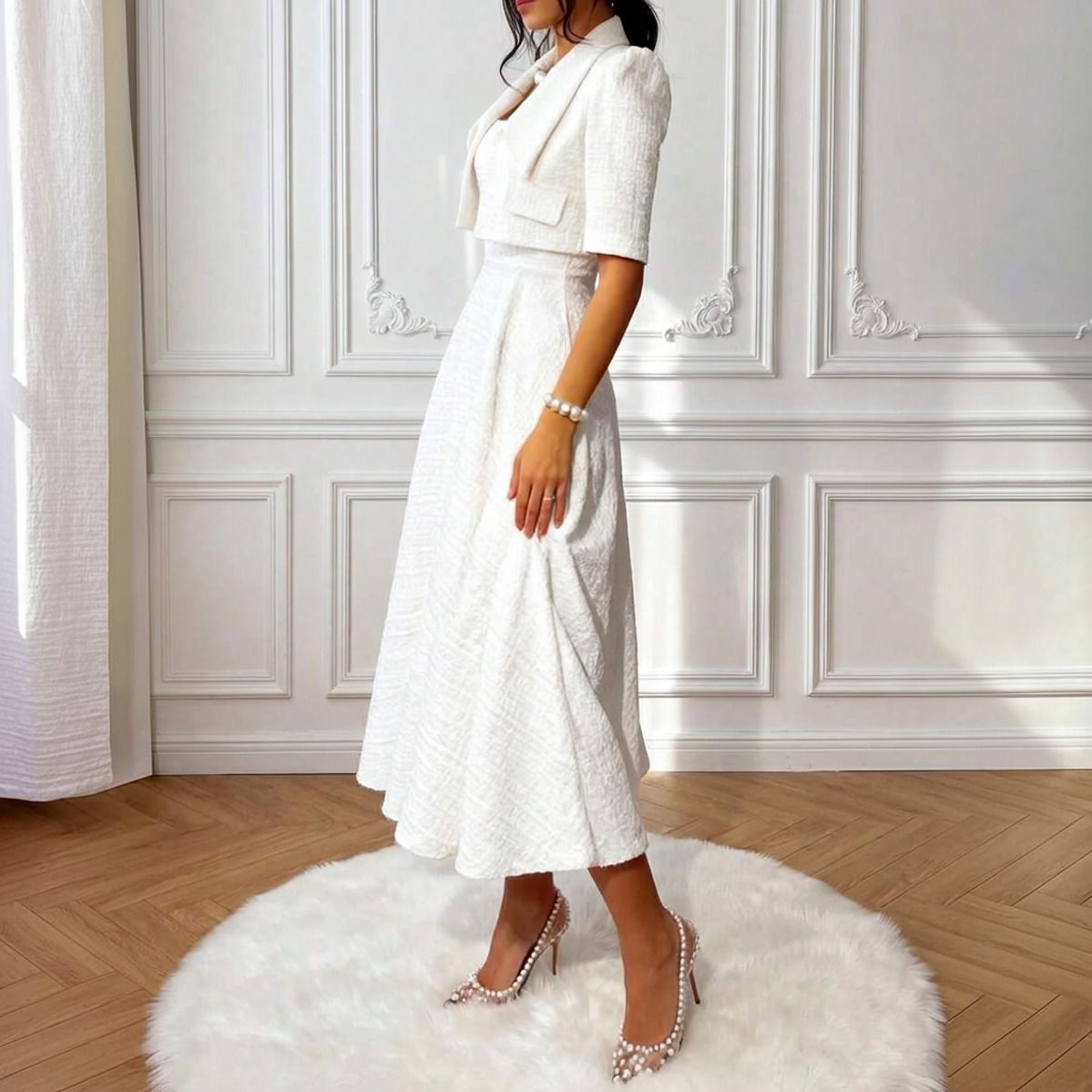 Vista lateral del vestido blanco tweed midi con chaqueta cropped, silueta evasé y largo bajo la rodilla