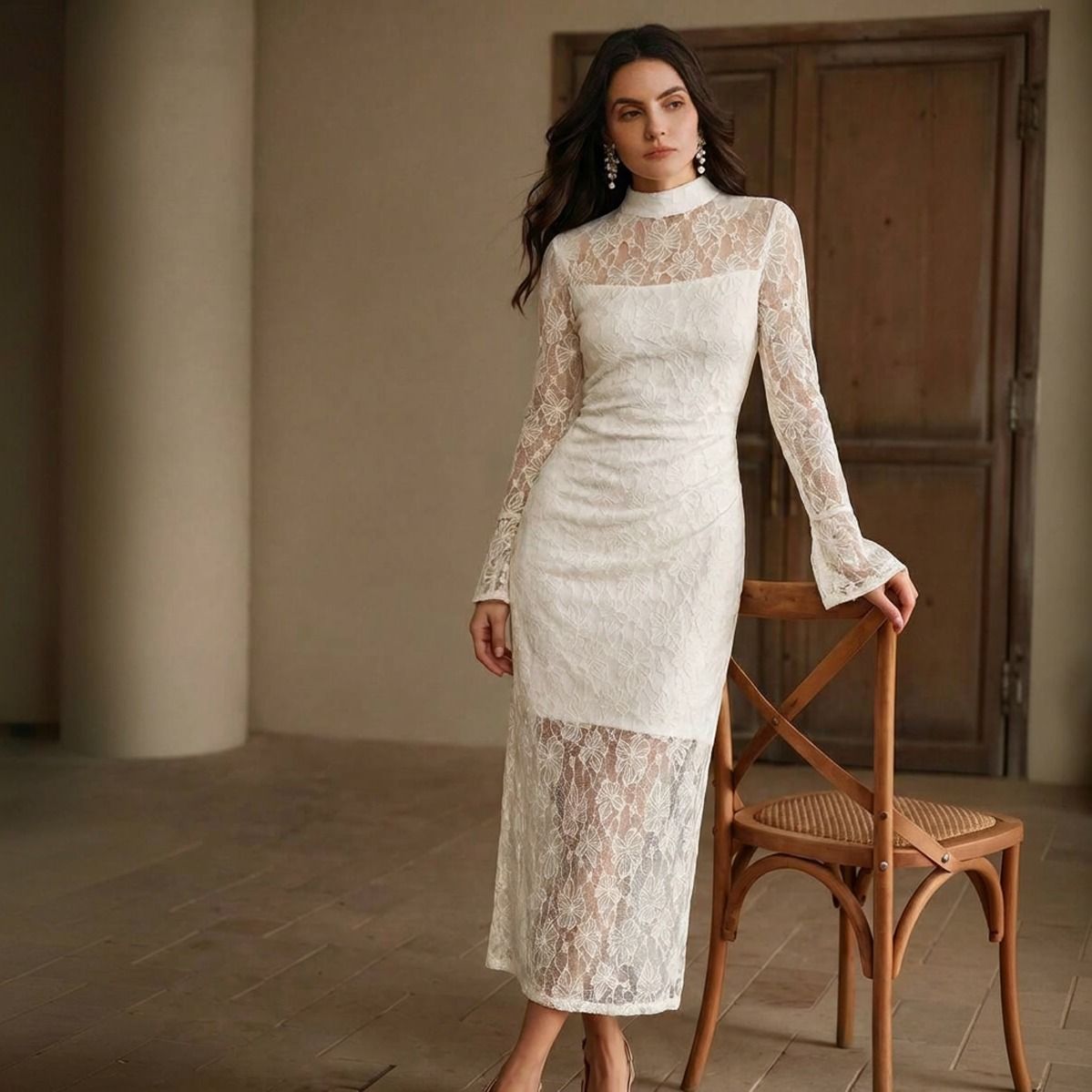 Vestido midi de encaje blanco ajustado con transparencia en ruedo y mangas largas acampanadas, vista completa de pie