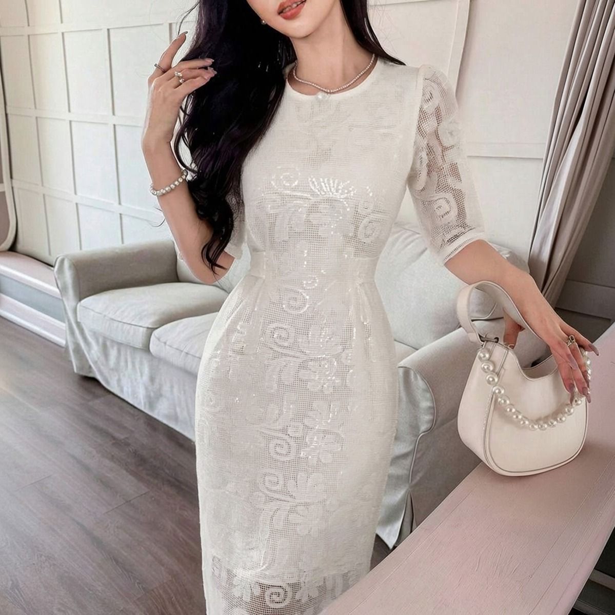 Detalle del torso y mangas de encaje floral semitransparente en vestido midi blanco con escote redondo