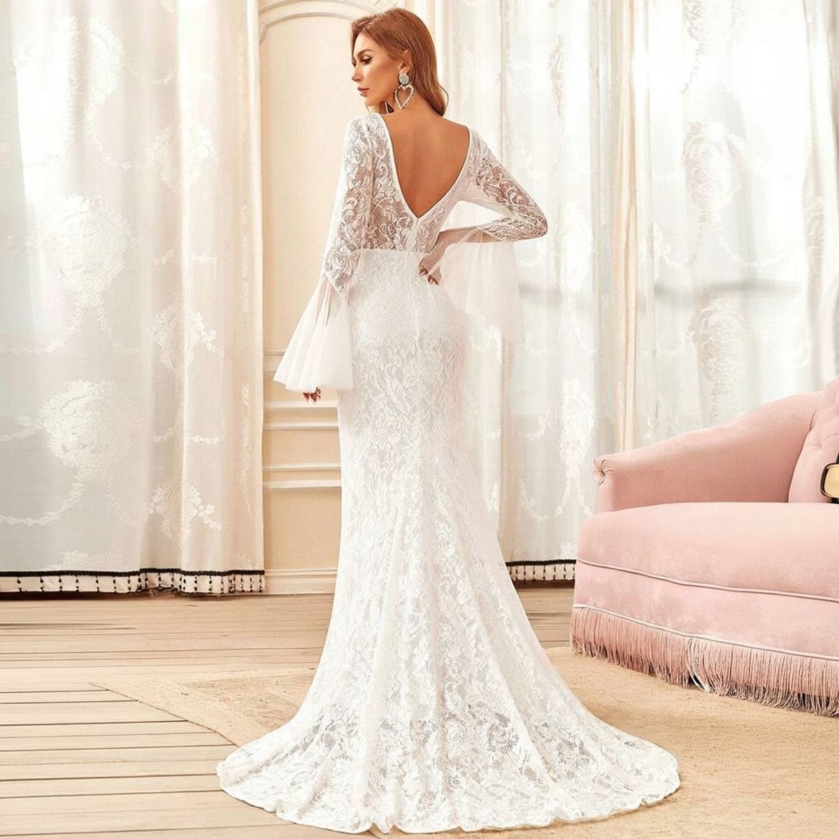 Vista trasera del vestido de novia sirena en encaje blanco mostrando escote V profundo en espalda y cola