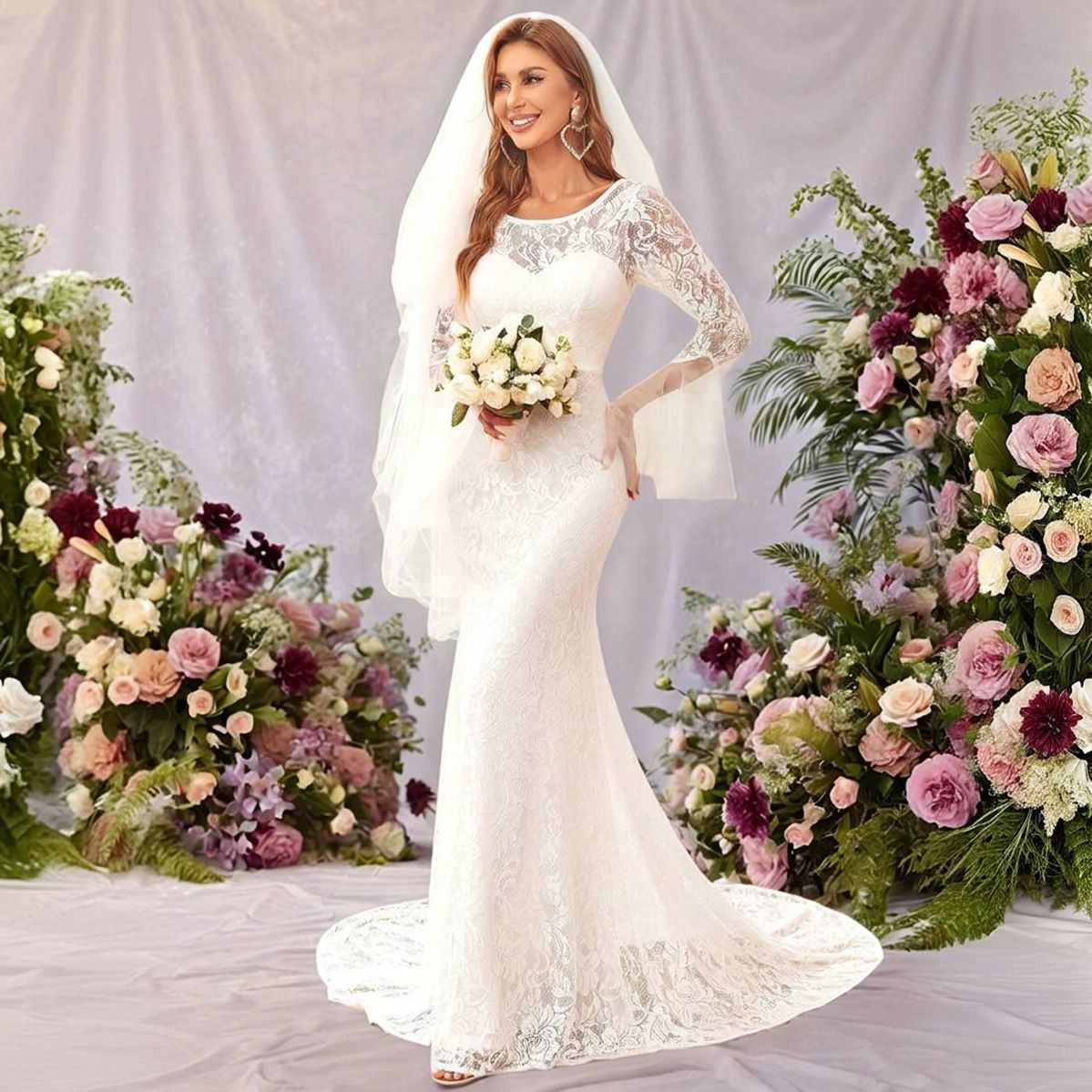 Modelo con vestido de novia sirena encaje blanco, velo y ramo, rodeada de arreglos florales en rosa y burdeo