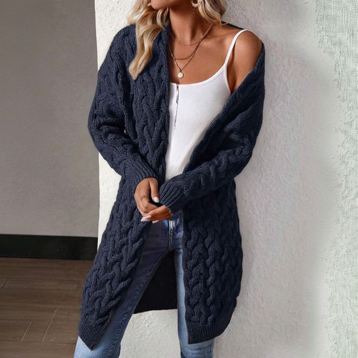 Detalle frontal del cardigan azul marino oversize con manga larga y puño acanalado, tejido trenzado grueso visible