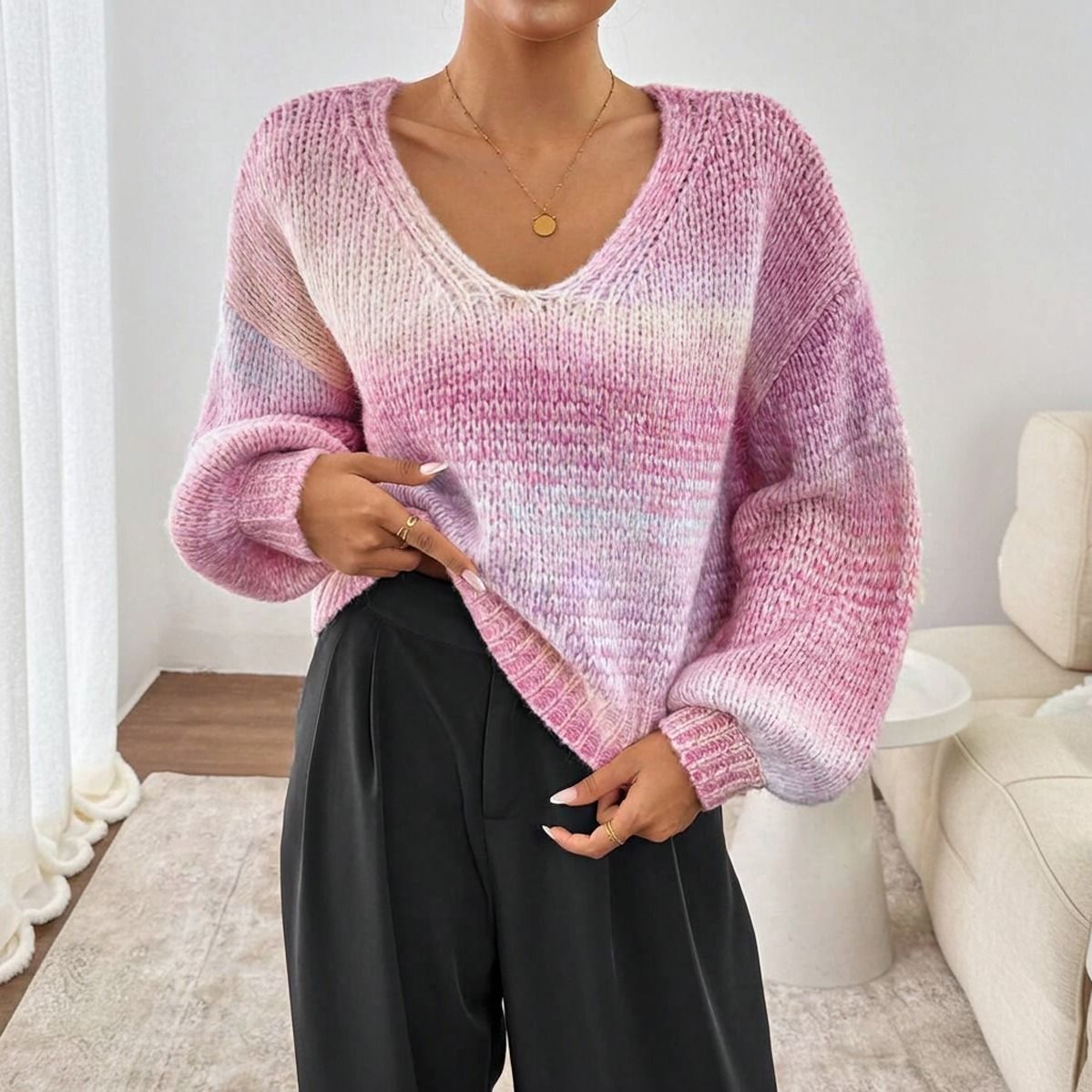 Sweater degradado rosa lila y blanco con escote V y mangas globo visto de frente sobre pantalon negro