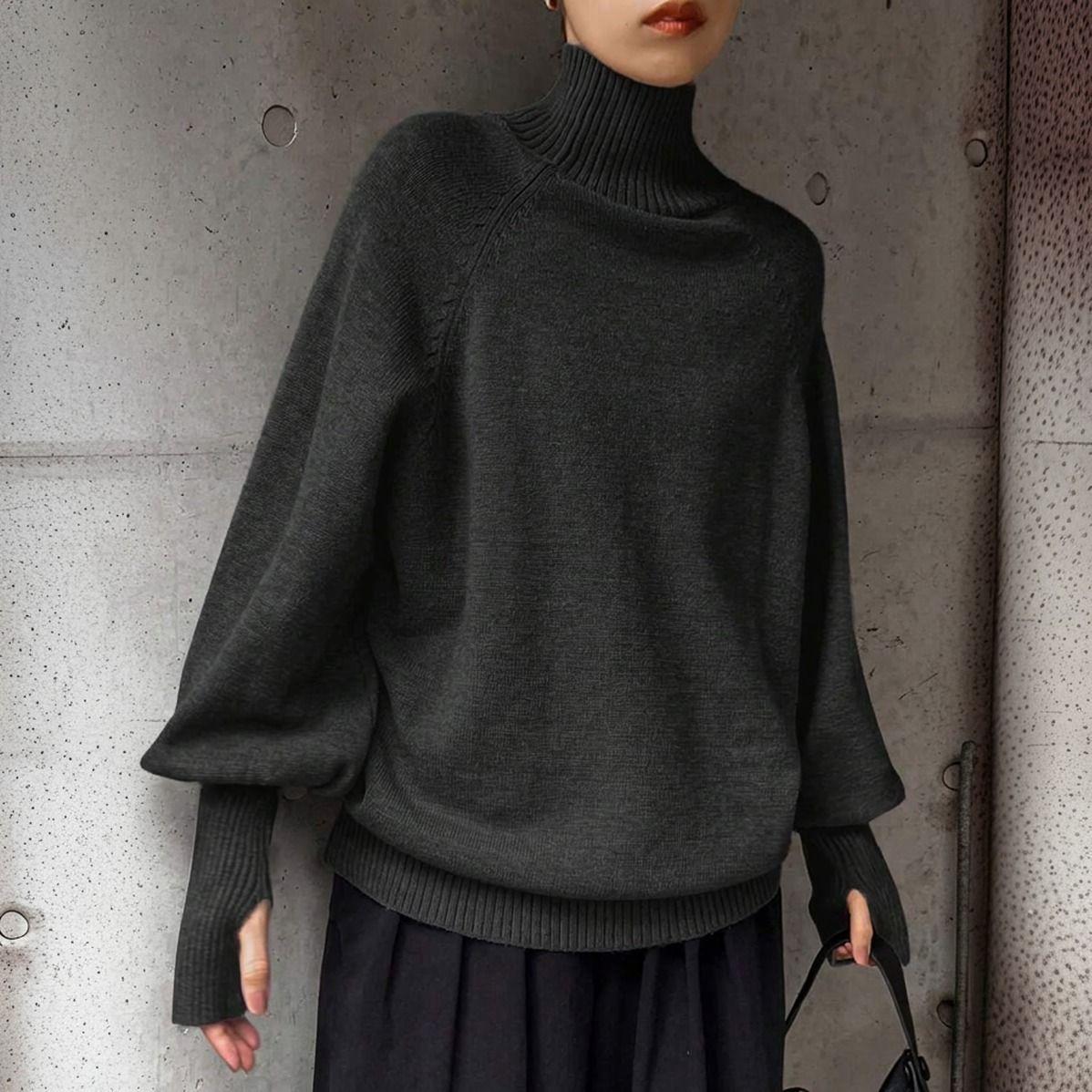 Sweater gris oscuro de punto oversize con cuello alto acanalado y mangas murciélago visto de frente