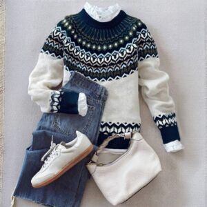 Sweater jacquard nórdico crema y azul marino en flat lay con jeans, zapatillas blancas y cartera crema