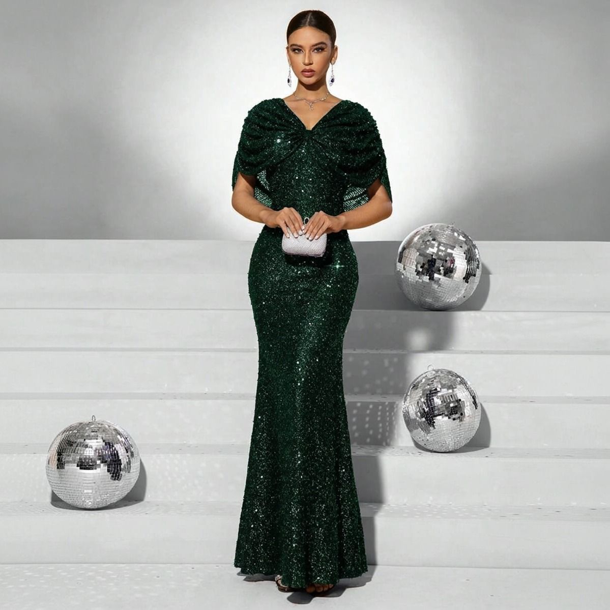 Vestido largo verde esmeralda en lentejuelas con silueta sirena, escote V y mangas drapeadas, vista frontal completa