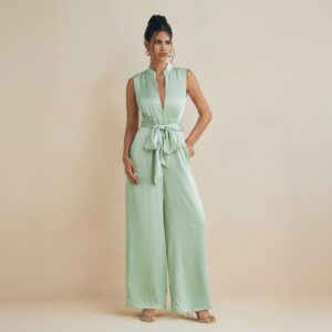 Modelo de frente con enterito verde menta sin mangas, escote en V y pantalón de pierna ancha con cinturón de lazo