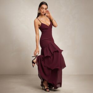 Vestido largo burdeos con escote V, tirantes finos y falda de volantes en gasa, vista frontal en movimiento