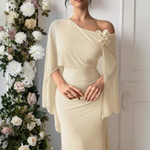 Detalle frontal del vestido marfil con capa de gasa, hombro descubierto y flor de tela aplicada en el escote