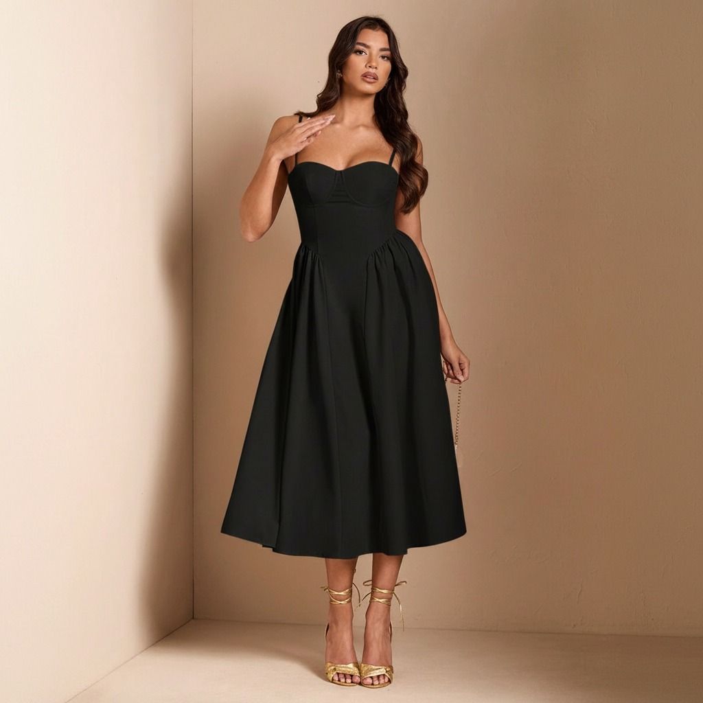 Modelo con vestido midi negro de escote corazón con copas marcadas, cuerpo corsé y falda evasé con volumen