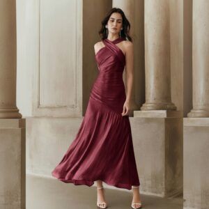 Vestido largo burdeos con escote halter cruzado y cuerpo drapeado, vista frontal de cuerpo completo