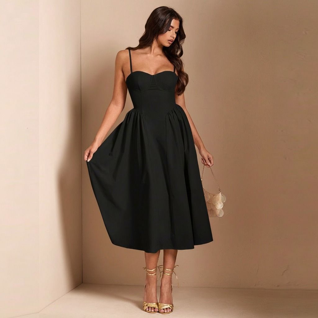 Vestido midi negro con falda evasé en movimiento, tirantes finos y cuerpo estructurado tipo corsé