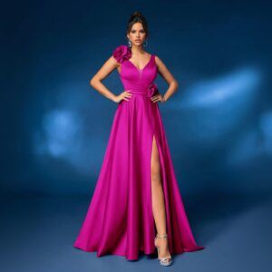 Modelo de frente con vestido largo de satén fucsia, escote en V y abertura frontal en la falda
