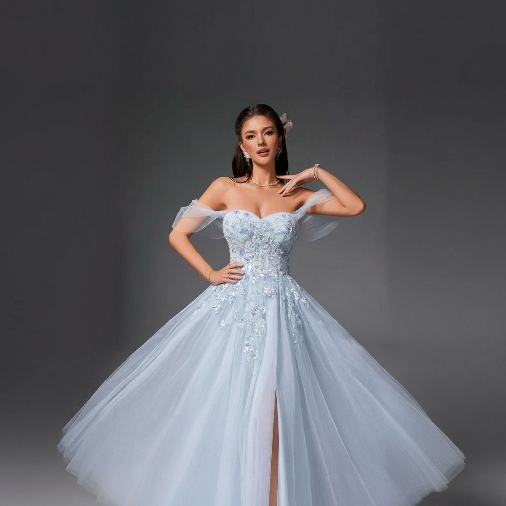 Plano medio del vestido celeste de tul con corsé bordado, mangas off-shoulder transparentes y falda con abertura frontal