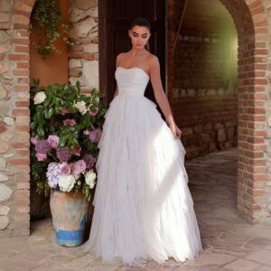 Vestido largo de tul blanco strapless con corpiño drapeado y falda de capas, vista frontal completa